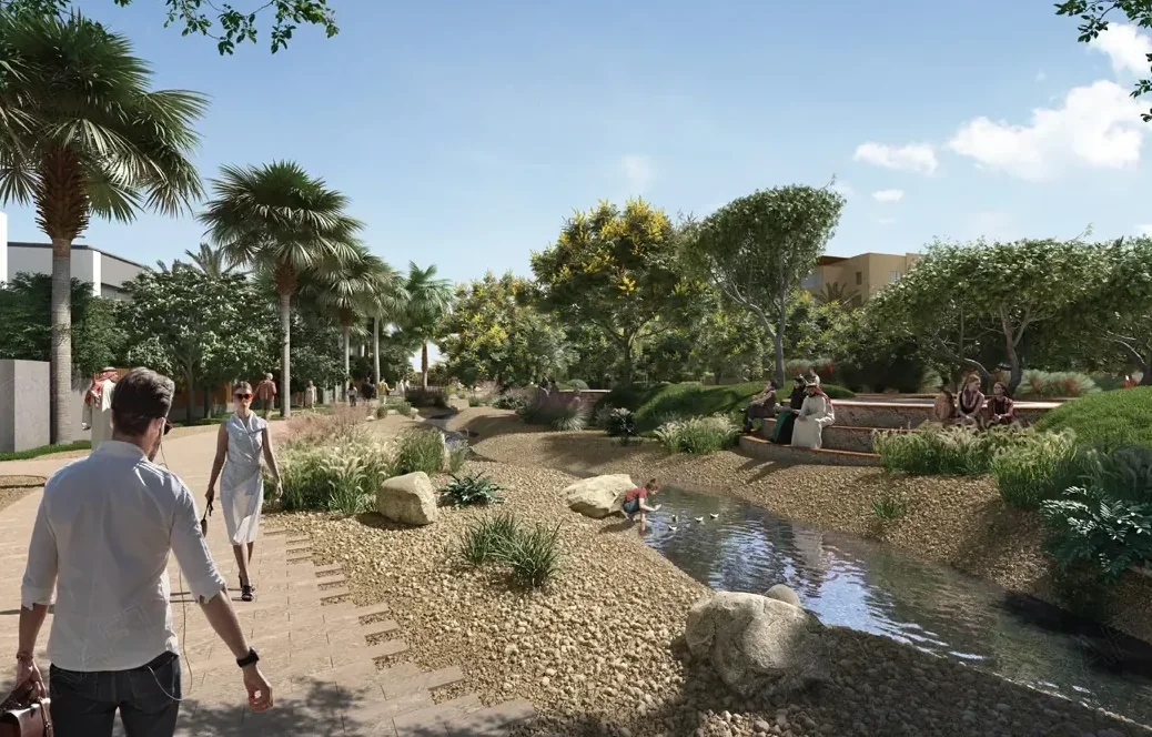 Visual of the dry wadi: a path along a stony stream bed, shaded by trees and edged with planting